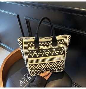 Detail of canvas tote bag showing black and white geometric patterns and woven texture
