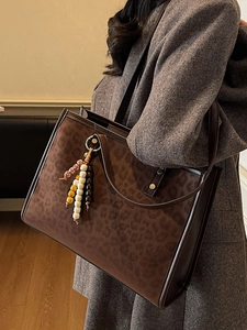 Large leopard print tote bag with charm styled with a gray wool coat for autumn