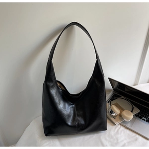 Close-up of black oil-wax leather texture on a minimalist commuter tote bag