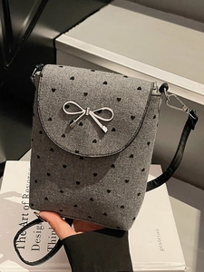 Mini gray felt crossbody bag with black heart patterns and a silver bow clasp detail