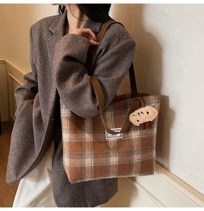 Detail of plaid tote bag in wool fabric with cute sheep charm and text label