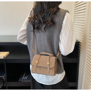 Dettaglio della piccola borsa quadrata kaki vintage con pelle opaca e fibbie dorate