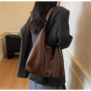 Detailed macro shot of deep brown soft leather tote bag with natural grain texture
