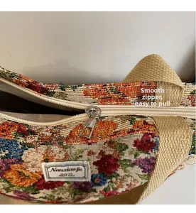 Détail de la fermeture éclair argentée et du motif floral ethnique sur le sac en toile