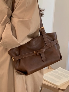 Retro brown faux leather shoulder bag worn with a stylish trench coat for a chic look