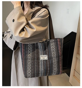 Detailed view of large ethnic tote bag featuring woven geometric patterns on a model