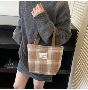 Brown plaid tote bag on shoulder, featuring chic wool fabric and retro Korean style design