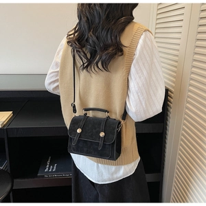 Borsa a tracolla retrò nera con fibbie dorate mostrata su modella per proporzioni e stile