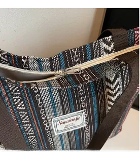 Detail shot of the silver metal zipper and woven stripes on a bohemian tote bag