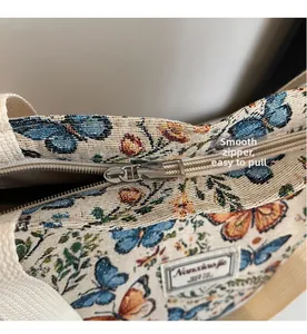 Close-up of a smooth silver metal zipper on a floral jacquard tote bag fabric
