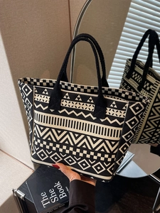 Large canvas tote bag with geometric patterns and woven handles for daily commuting