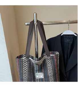 Detailed shot of ethnic style woven tote bag with colorful geometric patterns on a hanger