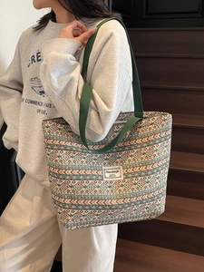 Ethnic style oversized woven tote bag with geometric patterns and green canvas strap