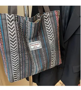 Close-up of woven tote bag with ethnic geometric patterns and brand patch on fabric