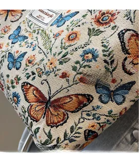 Macro shot of floral jacquard fabric with orange butterflies and brand label details