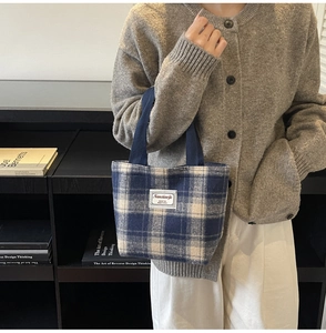 Detail shot of the blue and white checkered tote bag with a minimalist brand label
