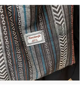Close-up of ethnic style woven tote bag with colorful geometric patterns and fabric tag