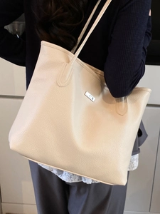 Sac cabas minimaliste en cuir grainé beige avec plaque argentée pour le transport quotidien