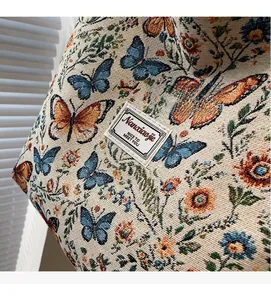 Close-up of floral butterfly jacquard fabric and brand label on large tote bag