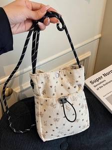 Chic cream corduroy crossbody bag with brown bow prints and woven rope strap
