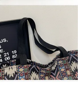 Detail of multi-color woven tote bag with durable black handles and ethnic geometric pattern