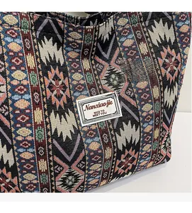 Detail of bohemian tote bag showing colorful woven geometric patterns and a logo label