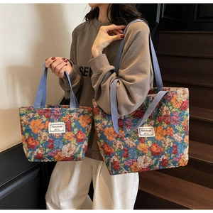Détails de grands et petits sacs fourre-tout à fleurs avec poignées bleues sur un modèle