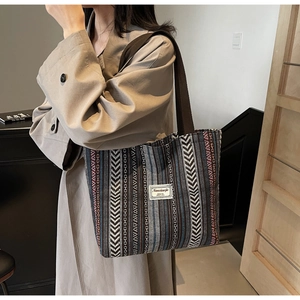 Detail view of ethnic striped canvas tote bag showing bohemian texture and fabric label