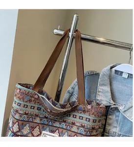 Detail view of ethnic woven tote bag featuring geometric patterns and brown handles