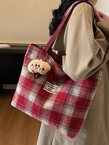 Red plaid tote bag with mushroom pendant shown on model for autumn fashion style