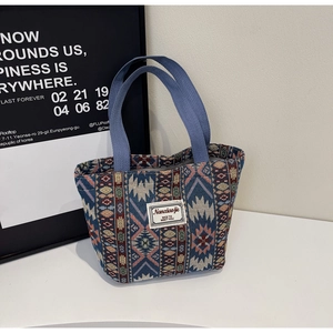 Gros plan d'un sac cabas ethnique avec motifs géométriques et anses tissées robustes