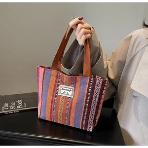 Close-up of bohemian woven tote bag with colorful geometric patterns and fabric brand label