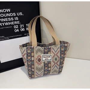 Détail d'un sac cabas tissé ethnique avec motifs géométriques colorés et étiquette en tissu