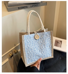 Linen bento tote bag featuring light blue floral texture and a round wooden button