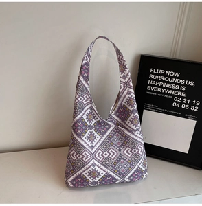 Dettaglio della borsa tote in tela con trama geometrica etnica viola e gialla