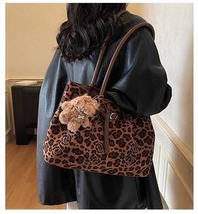 Close-up of leopard and rose pattern tote bag with a cute brown plush dog pendant