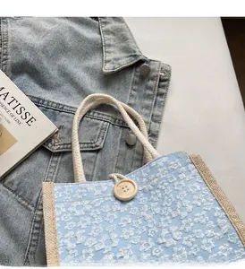 Detail of floral canvas lunch bag with rope handle and round wooden button closure