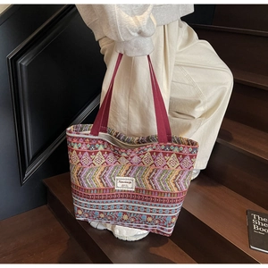 Ethnic style large tote bag with colorful geometric patterns and red woven handles