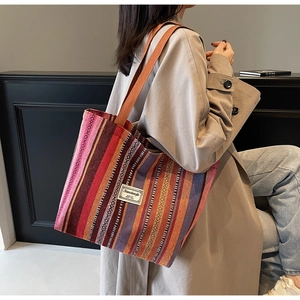 Detail of bohemian striped canvas tote bag with woven texture and shoulder straps
