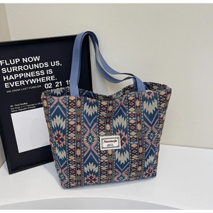 Détail du tissu jacquard ethnique et écusson de marque sur le grand sac cabas femme