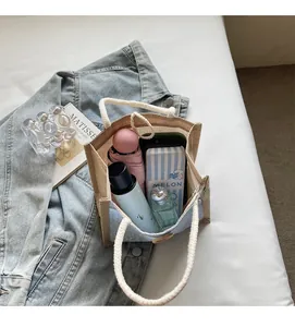 Internal view of the linen bento bag showing daily items like a water bottle and umbrella