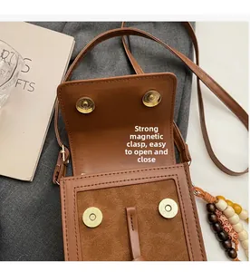Detail of vintage brown suede crossbody bag showing secure dual magnetic snap closures