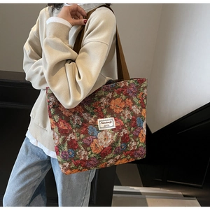 Détail du tissu jacquard floral coloré et de l'étiquette de marque sur un grand sac cabas