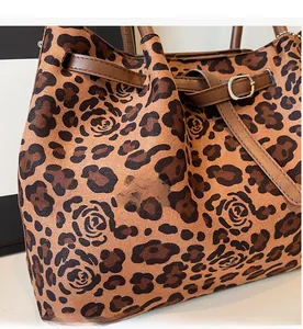 Close-up of leopard and rose floral print on high-capacity tote bag with leather strap