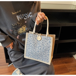 Close-up of floral linen bento bag with rustic rope handles and decorative wooden button