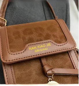 Close-up of brown leopard print crossbody bag with contrast stitching and metallic hardware