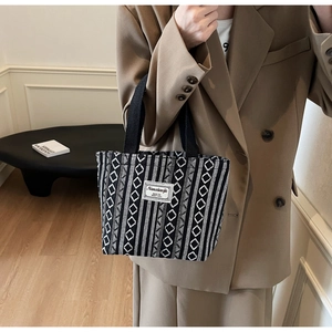Detail of black and white geometric ethnic weave on tote bag with branded fabric label