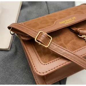 Gros plan de la boucle dorée réglable sur le sac à bandoulière marron au motif léopard