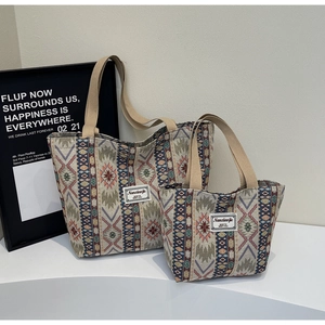 Gros plan sur la broderie ethnique et l'étiquette logo d'un grand sac cabas tissé