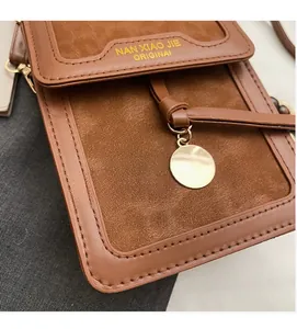 Detailed close-up of brown leopard print crossbody bag with gold pendant and brand text